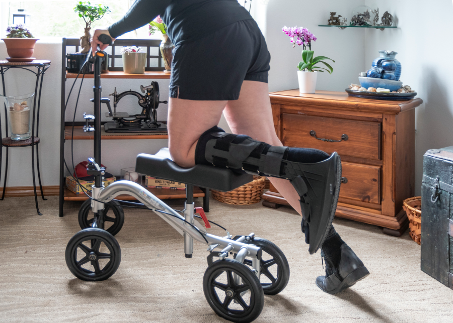 Person using a modern walking aid with knee braces indoors.