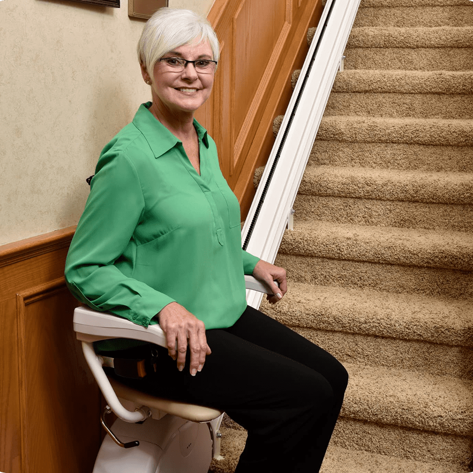 Woman sitting on a stair lift chair.